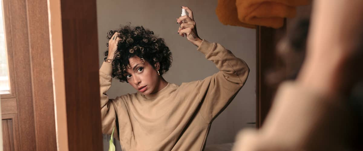 Haarstyling im Spiegel mit Pflanze im Vordergrund