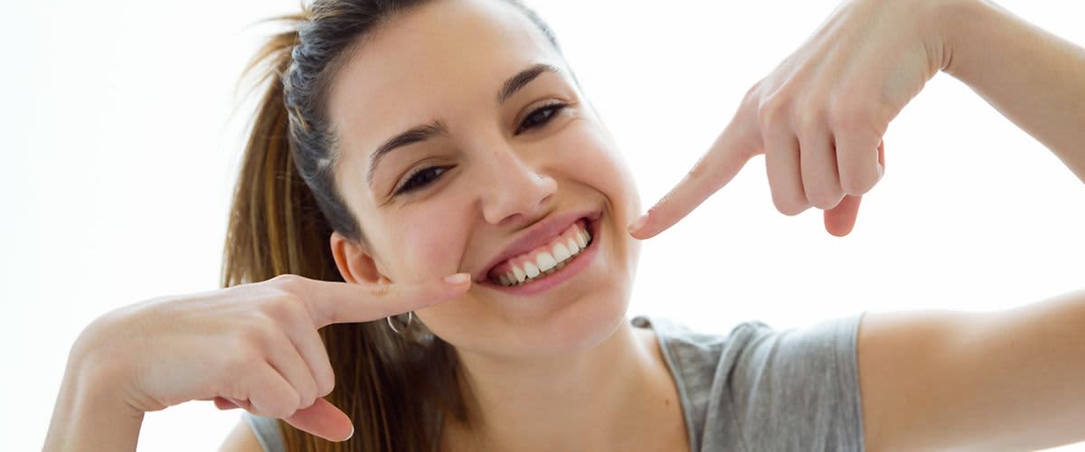 junge Frau lächelt und zeigt ihre Zähne