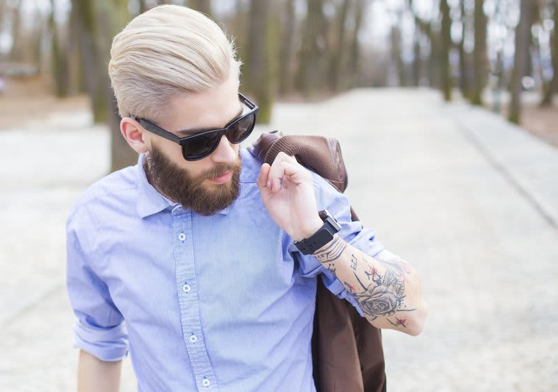 Mann mit hochgestylten Haaren und rosa Sonnebrille