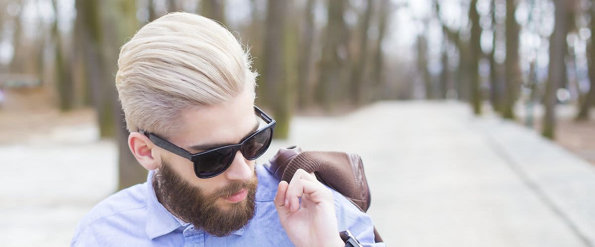 Mann mit hochgestylten Haaren und rosa Sonnebrille