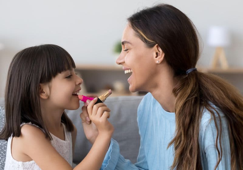 Mama und Tochter tragen sich Lippenstift auf