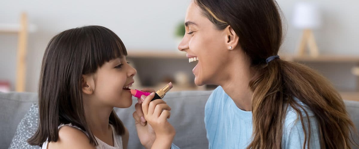 Mama und Tochter tragen sich Lippenstift auf