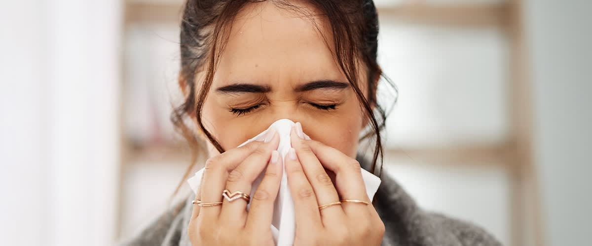 Verschnupfte Frau mit Taschentuch