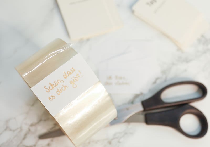 Kompliment auf Zettel, Klebeband und Schere