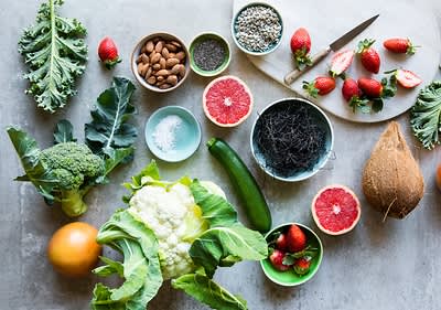 Frisches Gemüse und Obst auf einem Tisch mit Brokkoli, Erdbeeren und Kokosnuss