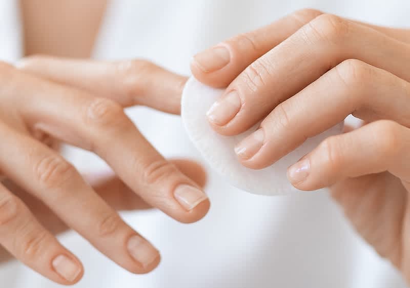 Frau reinigt Ihre Nägel