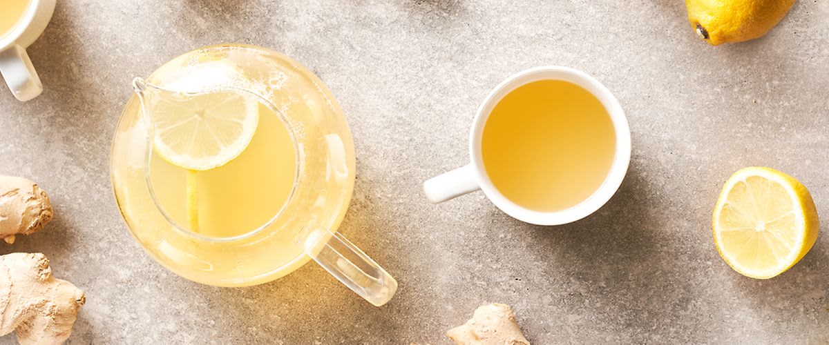Kanne und Tasse mit Tee, Zitronen, Ingwer