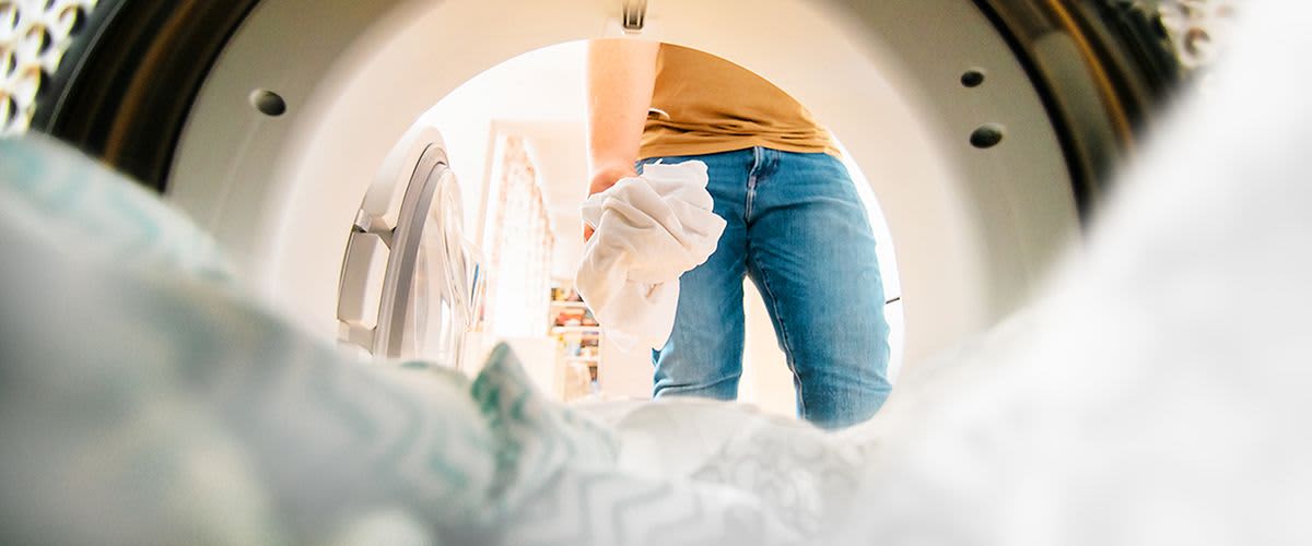 Wäsche wird in Waschmaschine gegeben