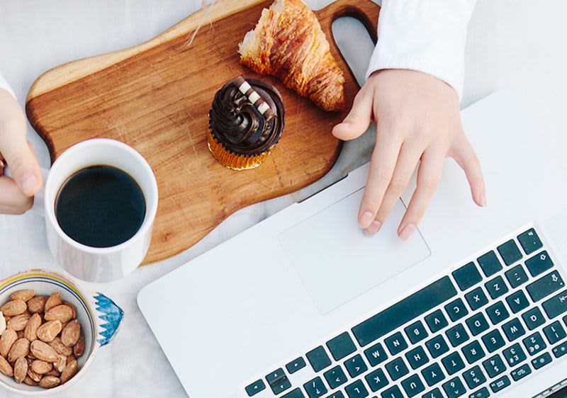 Person frühstückend am Arbeitsplatz