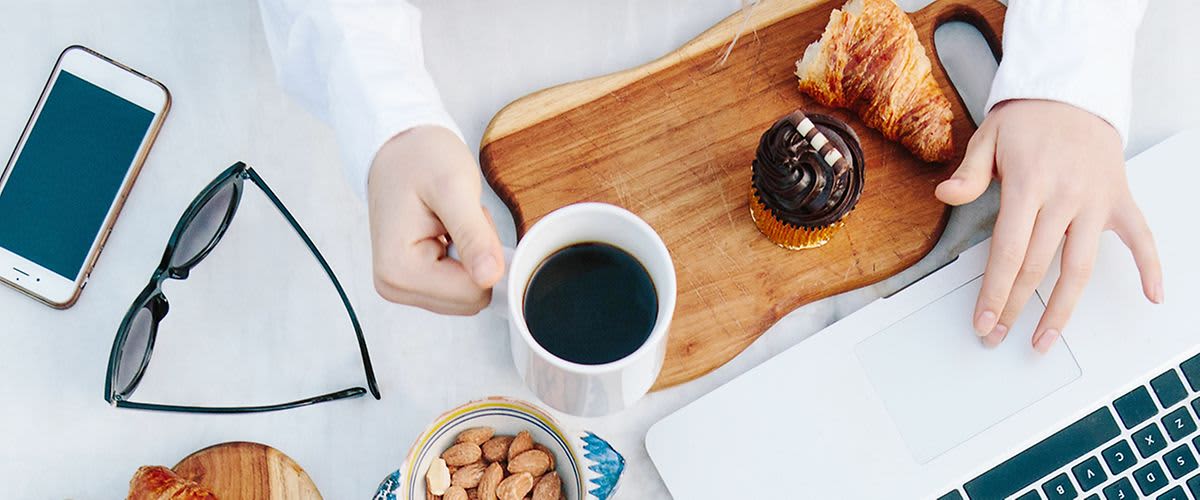 Person frühstückend am Arbeitsplatz