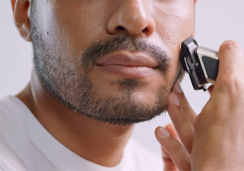 Mann rasiert sich mit Bartrimmer
