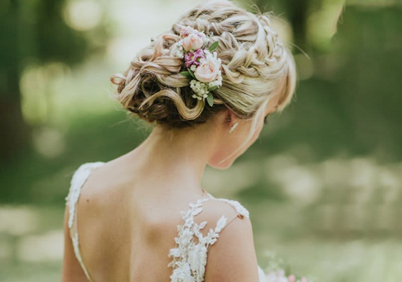 Braut mit Hochsteckfrisur und Blumen im Haar