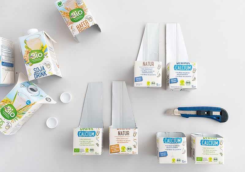 dmBio Tetrapacks und Cuttermesser auf weißem Hintergrund