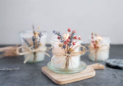 Duftkerze mit Kräutern und Beeren verziert