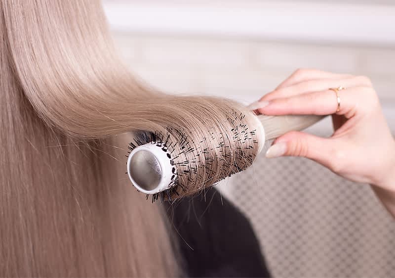 Haare werden mit Rundbürste gestylt