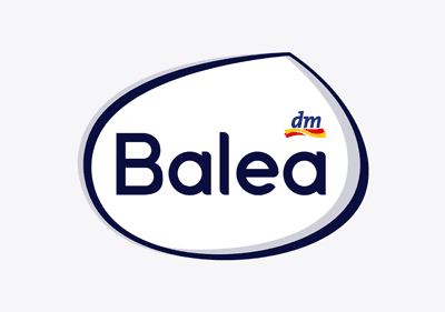 Das Bild zeigt das Logo der Marke Balea, bestehend aus einem weißen ovalen Hintergrund mit einem dunkelblauen Rand, in dessen Mitte der Schriftzug Balea in dunkelblauer Farbe steht, oben rechts ist das dm-Logo mit einem kleinen blauen dm und einer darunter verlaufenden gelben und roten Linie zu sehen.
