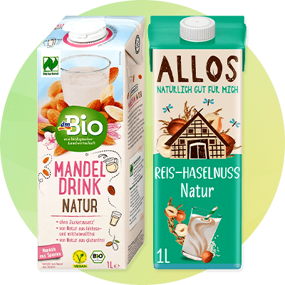 Links eine weiße Verpackung von dmBio Mandel Drink Natur mit Abbildung von Mandeln, rechts eine Verpackung von Allos Reis-Haselnuss Natur mit Illustration eines Hauses und Haselnüssen.