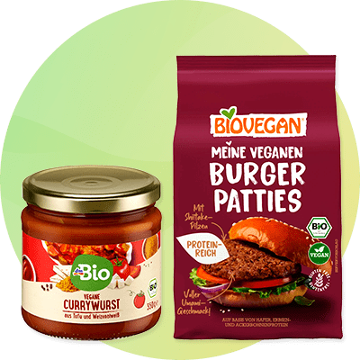 Ein Glas mit der Aufschrift „Vegane Currywurst“ neben einer Verpackung „Biovegan Meine Veganen Burger Patties“ mit Abbildungen von Burger und Pilzen