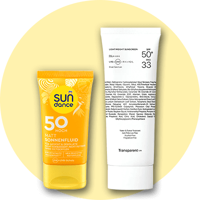 Eine gelbe Tube mit der Aufschrift „Sundance Matt Sonnenfluid 50 Hoch“ neben einer weißen Tube mit der Aufschrift „Lightweight Sunscreen SPF 50+ PA++++“