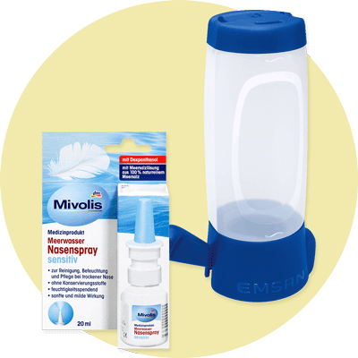 Eine Produktverpackung von Mivolis Meerwasser Nasenspray sensitiv mit blauer und weißer Gestaltung, daneben eine transparente Nasendusche mit blauem Standfuß