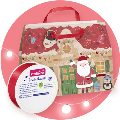 Eine Geschenkverpackung mit weihnachtlichem Design zeigt ein Haus mit rotem Dach, einem Schneemann und einem Weihnachtsmann. Daneben eine rote Geschenkbandrolle mit der Aufschrift „Profissimo Geschenkband“ und „Spende von 10 % an Recycling-Heroes“