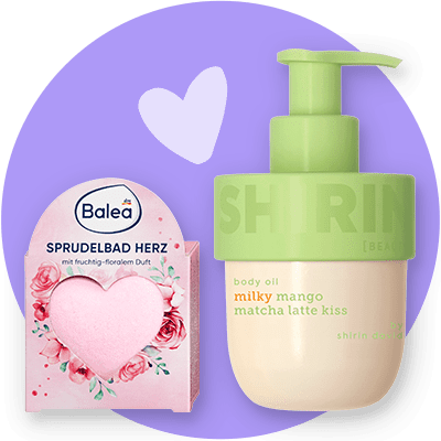 Links ein rosa herzförmiges Badepraliné in einer Verpackung der Marke Balea mit der Aufschrift „Sprudelbad Herz mit fruchtig-floralem Duft“, rechts eine grün-pastellfarbene Pumpflasche Körperöl von Shirin David mit der Beschriftung „body oil milky mango matcha latte kiss“