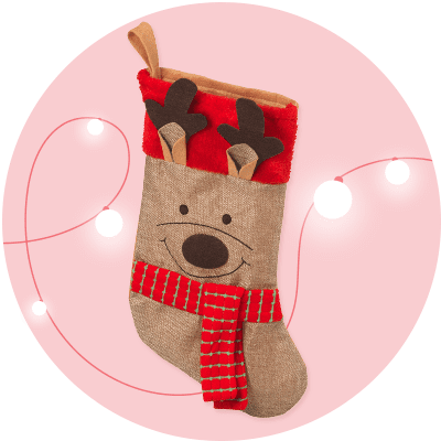 Ein Weihnachtsstrumpf in Form eines Rentiergesichts mit rotem Schal und Geweih auf rosa Hintergrund mit weißen Lichterketten