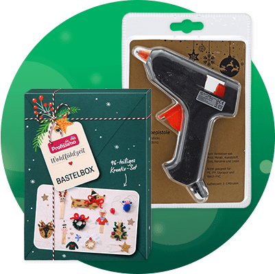 Eine schwarze Heißklebepistole auf einer Verpackung mit der Aufschrift „Heißklebepistole inkl. 2 Klebesticks“, daneben ein Jutesack mit einem weißen und roten Weihnachtsmann-Gesicht aus Filz