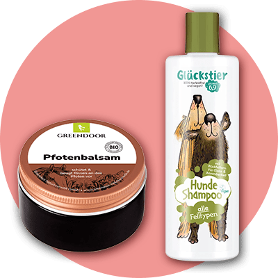 Eine Dose Pfotenbalsam von Greendoor mit braunem Deckel und die Flasche eines Hundeshampoos der Marke Glückstier mit einer Illustration von zwei Hunden