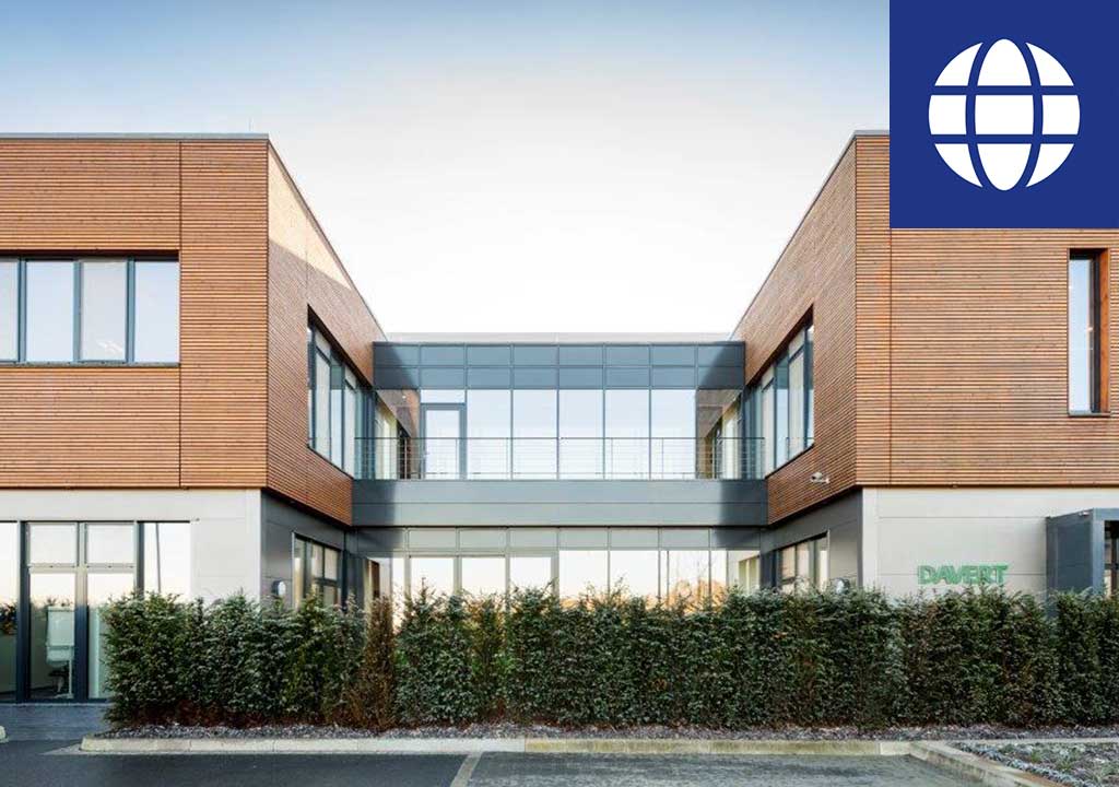 Eine Gruppe von Personen steht im Freien um einen großen blauen Behälter. Eine Person im Vordergrund trägt ein weißes T-Shirt und eine weiße Kappe mit dem Logo von Davert.