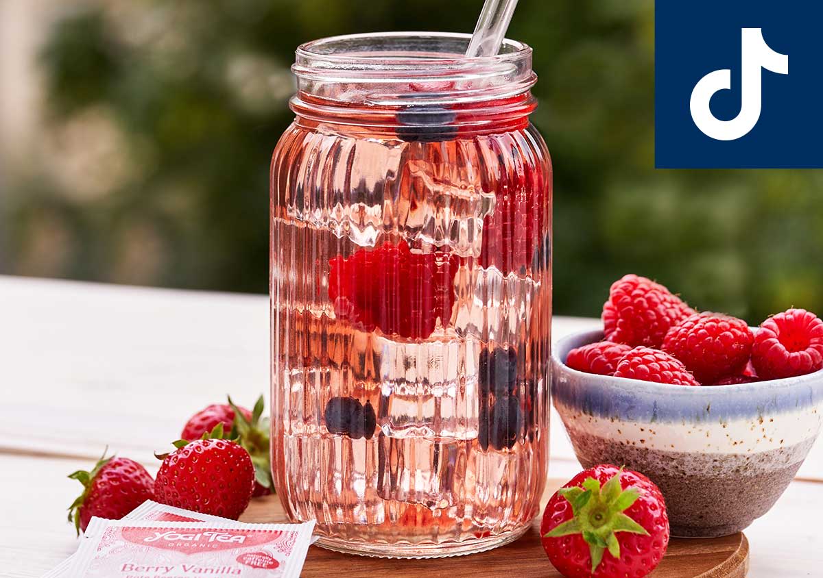 Ein Sommergetränk mit Erdbeeren auf einem Tisch im Garten mit TikTok Logo oben rechts