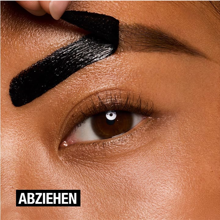 Nahaufnahme eines Auges mit brauner Iris, darüber wird dunkle Augenbrauenfarbe aufgetragen