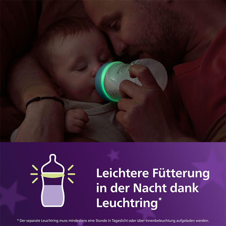 Ein Erwachsener hält ein Baby und füttert es mit einer Flasche. Darunter steht der Text: „Leichtere Fütterung in der Nacht dank“ auf einem lila Hintergrund mit einer Flaschenillustration.