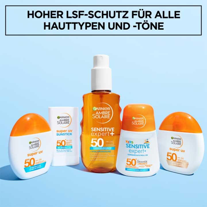 Fünf Sonnenschutzprodukte der Marke Garnier Ambre Solaire: in der Mitte ein orangenes Sprayfläschchen mit Aufschrift „Sensitive expert+ 50“, links und rechts jeweils ovale weiße Flaschen mit orangen Kappen und der Aufschrift „super uv 50“ sowie zwei rechteckige Flaschen mit „super uv 50“ und „kids Sensitive expert+ 50“ auf blauem Hintergrund