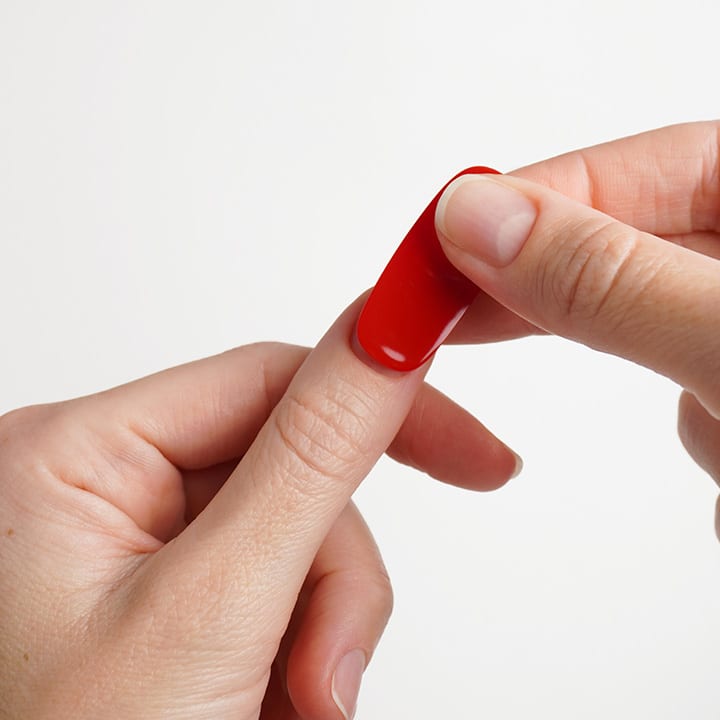 HĂ€nde, die einen kleinen roten Fingerpflaster auf den Daumen einer anderen Hand kleben