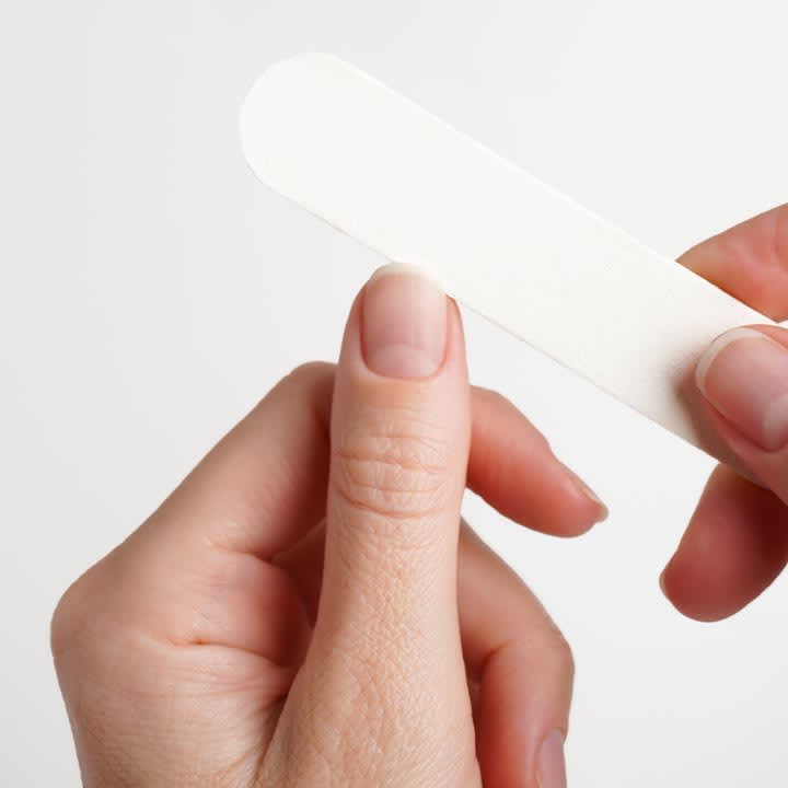 HĂ€nde feilen eine fingernagelkante mit einer weiĂen Nagelfeile