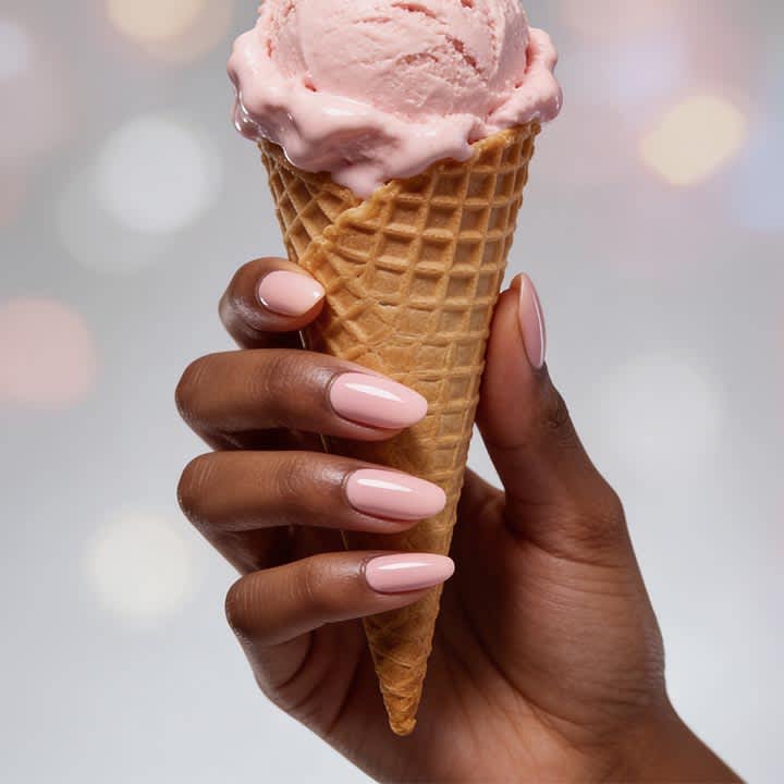Hand hält Eiswaffel mit einer Kugel rosa Eis, Fingernägel in hellrosa lackiert