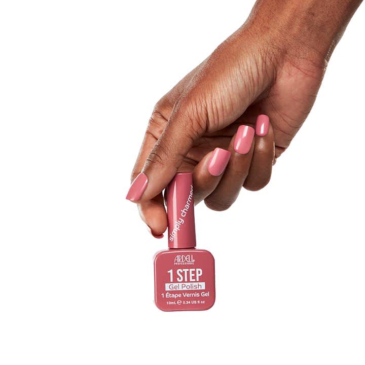 Hand mit lackierten rosa Nägeln hält eine rosa Flasche Ardell 1 STEP Gel Polish Nagellack mit deutlich lesbarem Schriftzug „1 STEP Gel Polish“