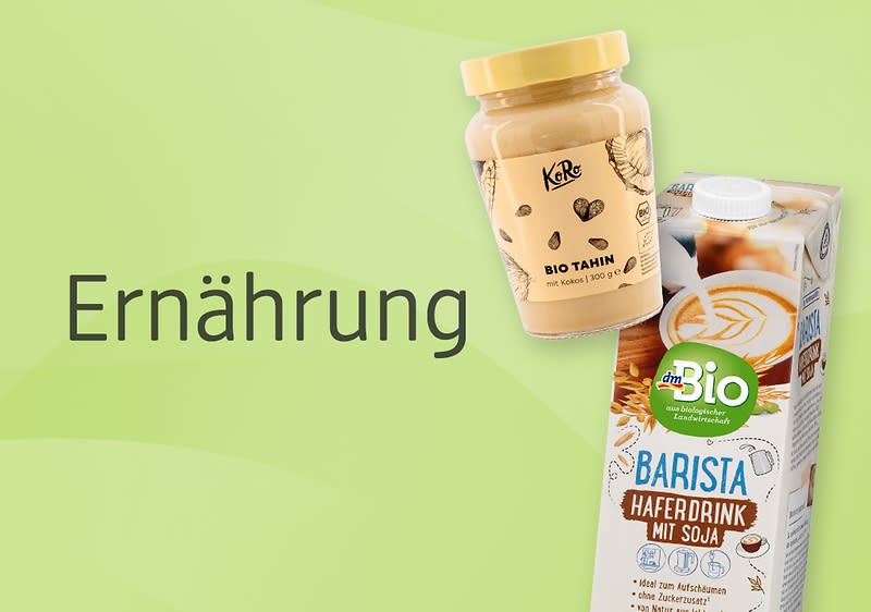 Auf einem hellgrünen Hintergrund sind ein Glas Tahin der Marke Koro mit braunem Deckel und schwarzem Schriftzug sowie eine Packung dmBio Barista Haferdrink mit Soja abgebildet, die Verpackung des Haferdrinks zeigt eine Tasse Kaffee und trägt die Aufschrift Barista Haferdrink mit Soja und dmBio, daneben steht das Wort Ernährung in schwarzer Schrift.