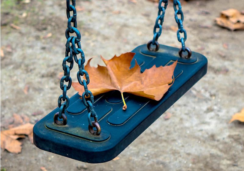 Leere Schaukel mit Laubblatt