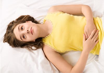 Mädchen hält sich die Hände vor den Bauch.