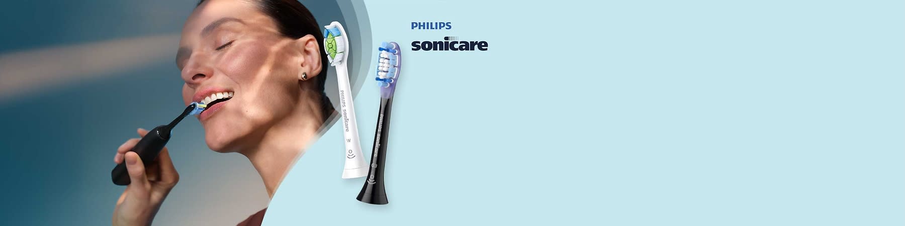 Zwei Zahnbürstenköpfe der Marke Philips Sonicare, einer in Weiß mit grünem und blauem Muster, der andere in Schwarz mit blauen Borsten, auf einem hellblauen Hintergrund