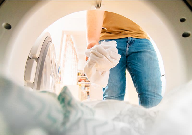 Wäsche wird in Waschmaschine gegeben