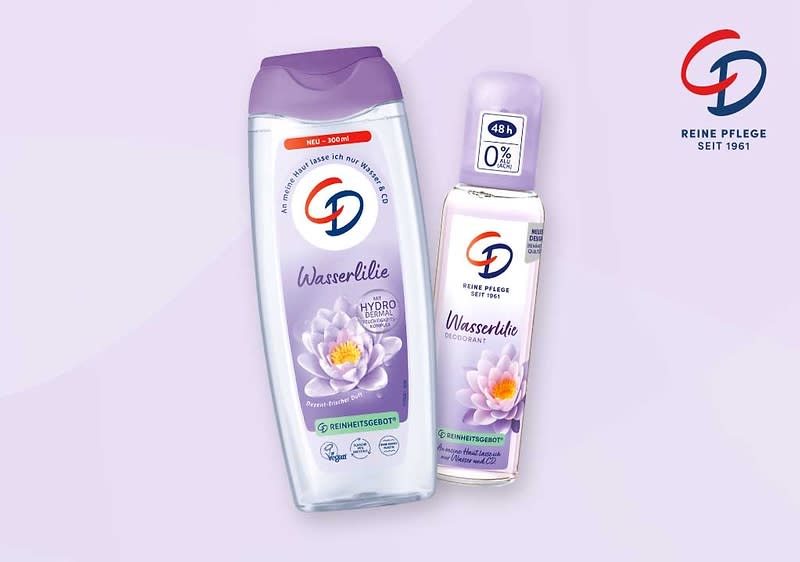 Zwei Produktflaschen der Marke CD in lila Farbtönen, links eine Duschgel-Flasche mit Aufschrift „Wasserlilie“ und Bild einer Seerose, rechts ein Deospray mit Aufschrift „Wasserlilie“ und Zusatzangabe „48h 0%“; rechts oben CD-Logo und Schrift „Reine Pflege seit 1961“