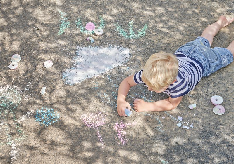 Kind malt mit selbst gemachter Malkreide