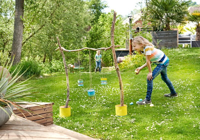 Kinder beim selbst gemachten Wurfspiel im Garten