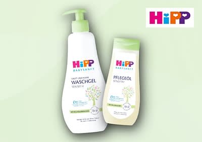 Zwei Produktverpackungen der Marke HiPP. Links eine weiße Flasche mit grünem Pumpspender und der Aufschrift „Haut und Haar Waschgel Sensitiv“, rechts eine weiße Flasche mit grünem Deckel und der Aufschrift „Pflegeöl Sensitiv“. Beide Verpackungen zeigen ein Baum-Design und tragen das HiPP-Logo