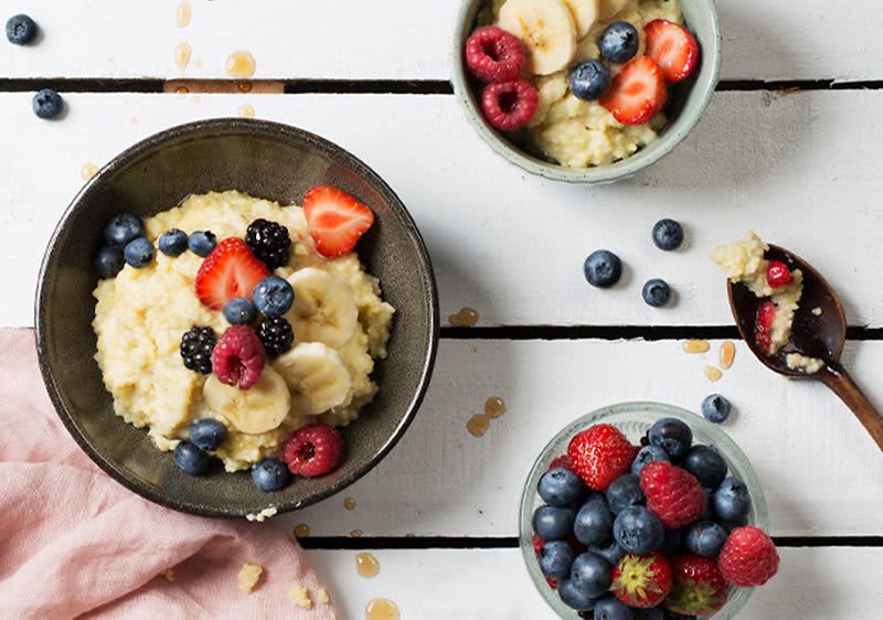Veganer Porridge mit Vanille und Hirse mit Beeren serviert