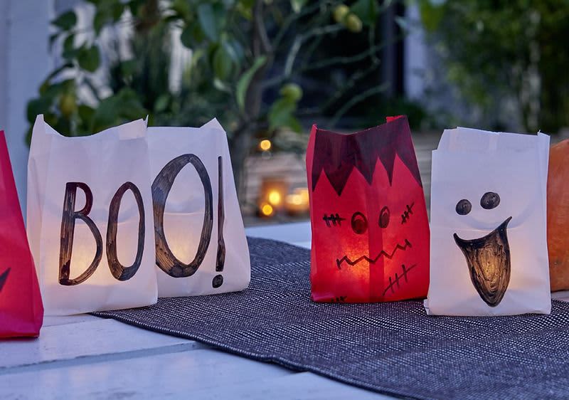 Papierlaternen mit Halloween-Motiven auf Tisch