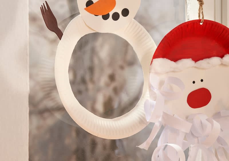 Weihnachtsmann und Schneemann als Deko am Fenster 